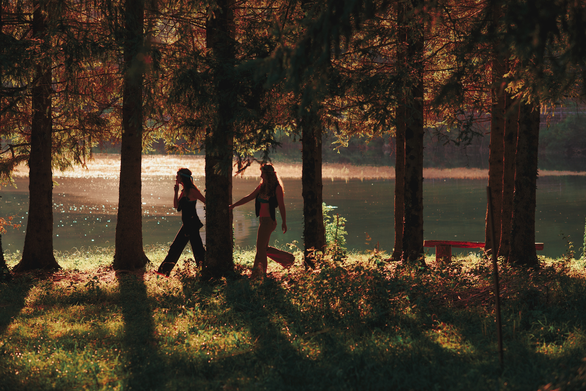 Dwie kobiety w stylizacjach hipisowskich idą przez las