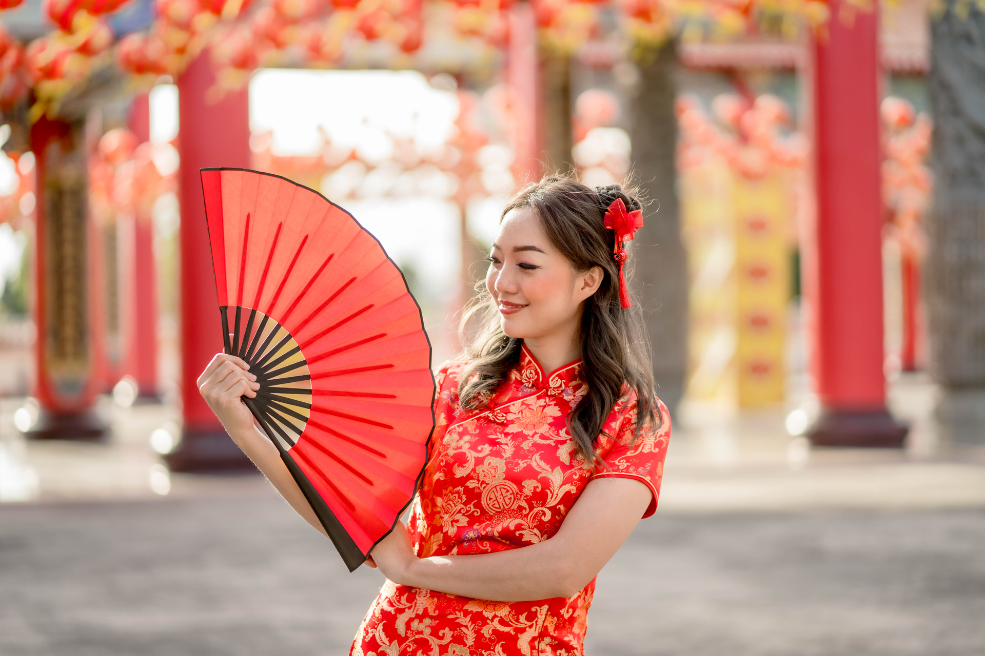 Kobieta w tradycyjnym chińskim stroju trzyma w dłoni wachlarz